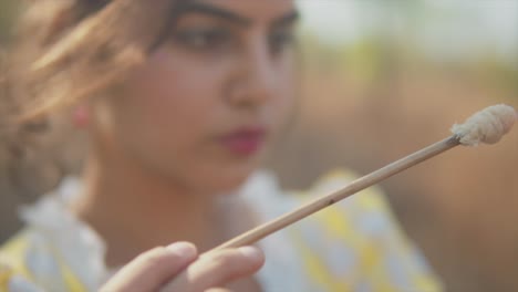 Closeup-shot-of-a-young-woman-with-a-septum-ring-dabbing-a-brush-unto-a-broken-piece-of-clay-pottery