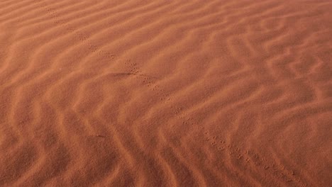 Textured-wind-patterns-on-red-sand-dunes-in-vast,-remote-wilderness-of-Wadi-Rum-desert-in-Jordan,-Middle-East