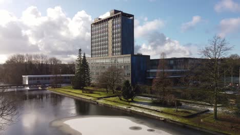 Pilkingtons-glass-head-quarters-blue-high-rise-business-office-park-aerial-view-low-over-snowy-lake