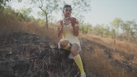 Verträumte-Weite-Zeitlupenaufnahme-Eines-Schönen-Indischen-Mädchens-In-Einem-Gelben-Kleid,-Das-Ein-Zerbrochenes-Stück-Keramik-Repariert