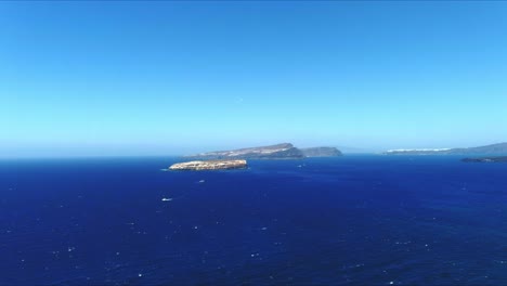 Vista-Aérea-4k-Azul-Mar-Y-Cielo-Sobre-Akrotiri-Santorini-Grecia-Con-Pájaros-Volando