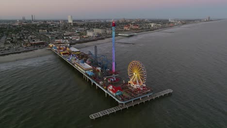 Aerial-view-around-the-Galveston-Island-Historic-Pleasure-Pier,-fall-evening-in-USA---circling,-drone-shot