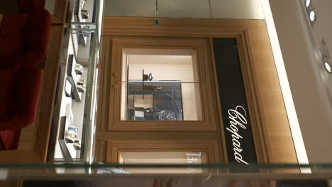 Elegant-Chopard-brand-wristwatch-display-inside-luxurious-golden-Barcelona-jewellery-store-interior
