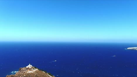 Aerial-4K-Blue-Sea-and-Sky-Top-View-Over-Akrotiri-Lighthouse-Towards-Horizon-in-Santorini-Greece