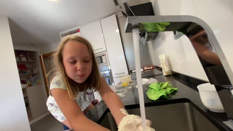 girl-washing-her-hands-full-of-flour-after-playing-cooking