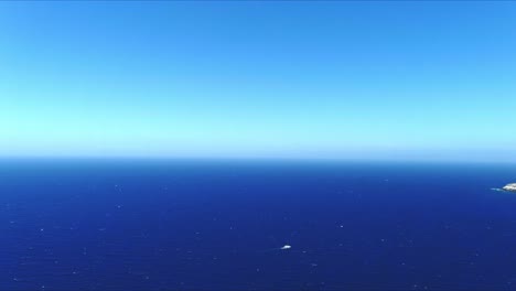 Vista-Aérea-4k-Azul-Del-Mar-Y-El-Cielo-Sobre-Akrotiri-Santorini-Grecia-Sobre-El-Barco-En-El-Agua