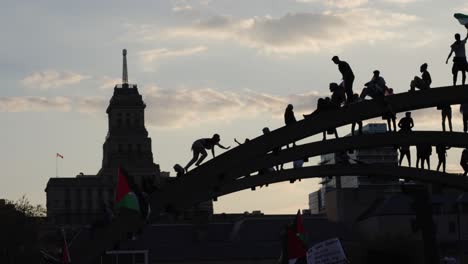 Free-Palestine-Protesters-climbing-arch