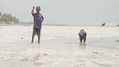 Zwei-Junge-Schwarze-Afrikanische-Jungs-Spielen-Im-Wasser-Am-Strand-In-Tansania
