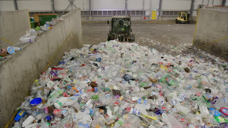 Bagger-Oder-Lader,-Der-Einen-Haufen-Plastikmüll-In-Der-Recyclingfabrik-Schiebt
