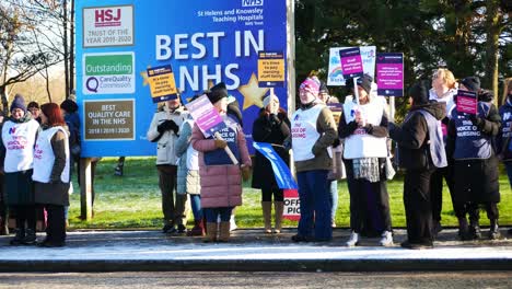 UK-hospital-nurses-protest-for-fair-pay-wages,-holding-banners-and-flags-on-strike