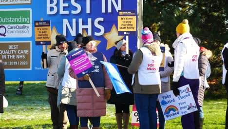 UK-hospital-healthcare-nurses-protest-for-fair-pay,-holding-banners-and-flags-on-strike