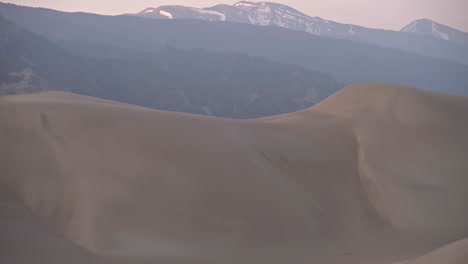 Panning-down-massive-sand-dune-to-small-backpacking-tent