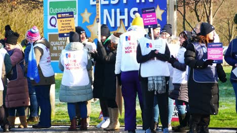 Britische-Krankenhauskrankenschwestern-Protestieren-Mit-Streikposten-Für-Faire-Bezahlung-Und-Halten-Banner-Und-Fahnen-Im-Streik