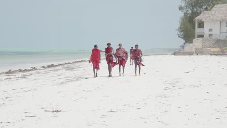 Gruppe-Afrikanischer-Stammesleute,-Die-In-Heißer-Sommersonne-Am-Sandstrand-Spazieren-Gehen