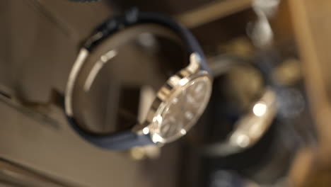 VERTICAL-bokeh-close-up-expensive-watches-in-luxury-jewellery-display,-shallow-focus