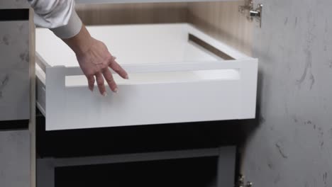 Woman-with-painted-fingernails-opens-and-closes-cabinet-drawer