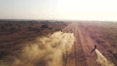 Vista-Aérea-De-Drones-De-Carreras-De-Bueyes-O-Vacas-En-Un-Campo-Polvoriento-En-India