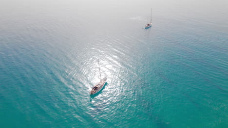 Zwei-Kleine-Segelboote,-Die-Auf-Türkisblauem-Wasser-Schwimmen