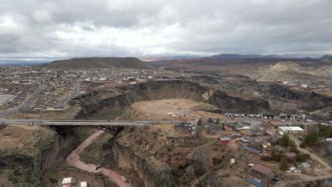 Puente-Sobre-El-Río-Virgen-En-La-Verkin,-Utah-Con-Una-Panorámica-Aérea-Revelada-De-La-Ciudad