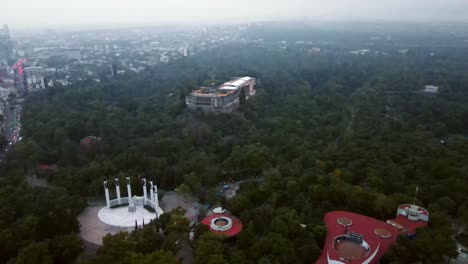 Aerial-view-truck-left-of-Chapultepec-Castle-surrounded-by-lush-trees-on-a-completely-hazy-day-in-Mexico-City
