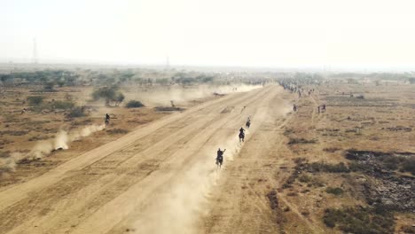Aerial-drone-view-of-a-horse-race-in-a-dusty-field-in-India