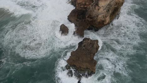 Rückzug-Vom-Vorgebirge-Von-Nazare,-Der-Ozeanwellen-Enthüllt,-Die-Gegen-Felsen-Prallen,-Ein-Berühmter-Surfspot-In-Portugal