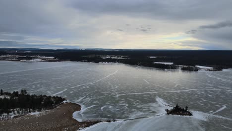 Eine-Winterliche-Luftaufnahme-Des-Zugefrorenen-Sees-Lac-La-Hache-In-British-Columbia,-Kanada