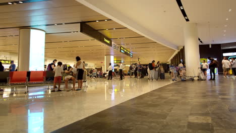 Gente-Esperando-En-El-Aeropuerto-De-Singaproe-Changi-Con-Equipaje