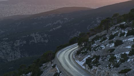 Aerial---Mountain-road-with-Athens-city-in-the-background-at-sunset---Shot-on-DJI-Inspire-2-X7-50mm-RAW