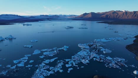Jokulsarlon-lagoon-icebergs-during-calm-sunset---Sideway-aerial-dolly