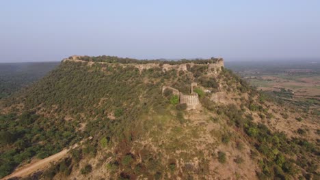 Aerial-drone-shot-of-an-ancient-fort-on-top-of-a-hill-in-Gwalior,-India