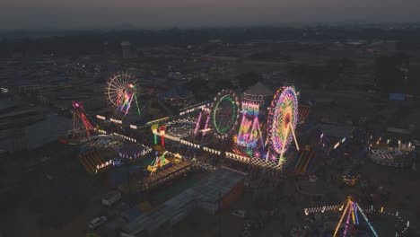 Closeup-Aerial-drone-shot-of-an-Indian-Amusement-park-,-Ferris-wheel-and-different-rides-at-night-lighting-at-Gwalior-Trade-fair,-India