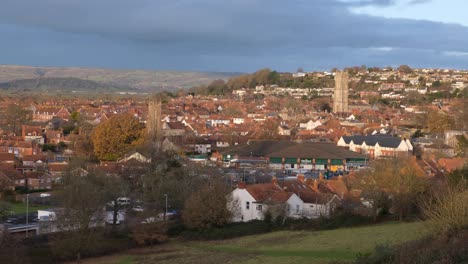West-country-town-of-Glastonbury-in-Somerset-with-red-brick-houses,-buildings-and-churches-in-rural-English-countryside-town