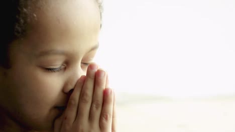 little-boy-praying-to-God-with-hands-together-on-white-background-with-people-stock-video-stock-footage