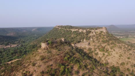 Aerial-drone-shot-of-an-ancient-fort-on-top-of-a-hill-in-Gwalior,-India