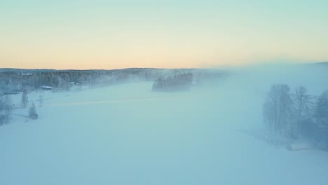 Drone-flying-through-fog-on-snowy-fields-on-a-sunny-winter-morning