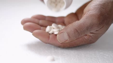 pills-from-a-bottle-being-poured-in-hand-with-white-background-stock-video-stock-footage