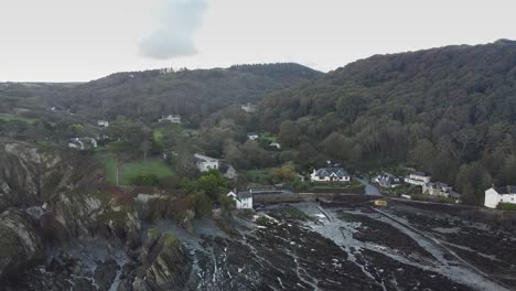Aerial-drone-orbit-of-a-small-coastal-town-in-a-valley-on-an-overcast-day---Lee-Bay,-Beach,-Ilfracombe,-Devon,-England