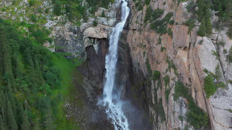 Drone-shot-Barskoon-Waterfall-in-Fairy-Tale-Canyon-in-Kyrgyzstan,-wide-revealing-aerial-footage
