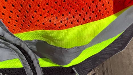 close-up-macro-of-a-hi-viz-safety-vest-moving-up-the-vest-in-bright-daylight