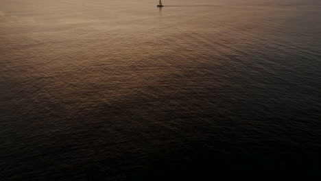 Sailboat-In-The-Sea-In-The-Evening-Sunlight-In-Guanacaste,-Costa-Rica---aerial-drone-shot