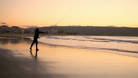 Fisherman-Throwing-Forward-His-Stick-Towards-Sea-At-Sunrise