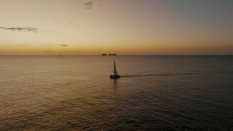 Boat-At-Sunset-On-The-Sea-Horizon-In-Guanacaste,-Costa-Rica---aerial-drone-shot