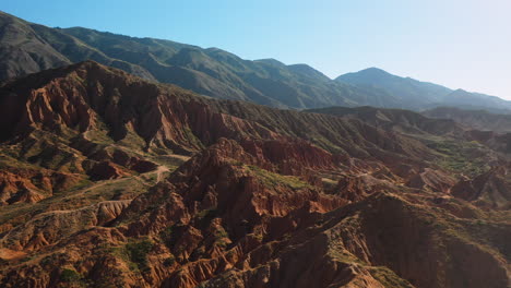 Cinematic-descending-drone-shot-flying-over-mountain-ridges-at-Fairy-Tale-Canyon-near-Issyk-Kul-Lake-in-Karakol,-Kyrgyzstan