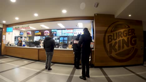 Mensajeros-Esperando-Pedidos-De-Comida-En-El-Mostrador-De-Pedidos-Dentro-Del-Restaurante-Burger-King---Bruselas,-Bélgica