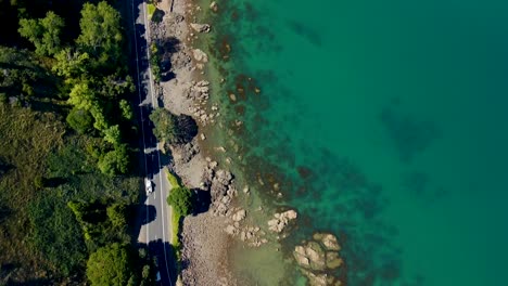 Cinematic-reveal-of-glass-off-ocean-flying-along-state-highway-25-in-the-Coromandel-Peninsula,-New-Zealand