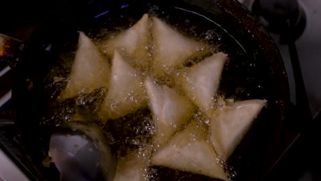 Overhead-View-Of-Samosas-Being-Stirred-In-Hot-Bubbling-Oil-In-Frying-Pan