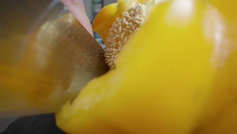 Ein-Koch-Schneidet-Eine-Gelbe-Paprika-Auf-Einem-Schneidebrett