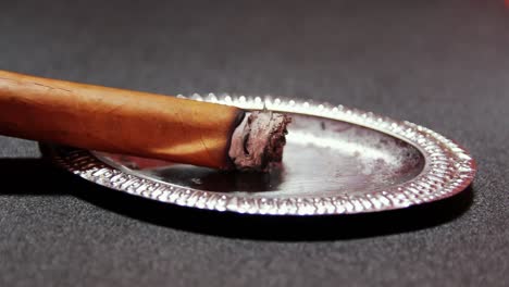 Beleuchtete-Zigarre-Auf-Silbernem-Aschenbecher