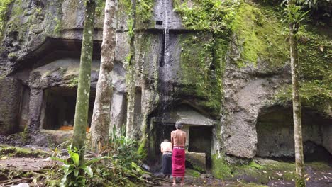 Balinesische-Männer-Beten-Unter-Wasser-Im-Goa-Garba-Tempel,-Bali,-Rituelles-Melukat,-Gianyar-Regentschaft,-Alte-Steinhöhle-Aus-Dem-12.-Jahrhundert,-Hinduismus